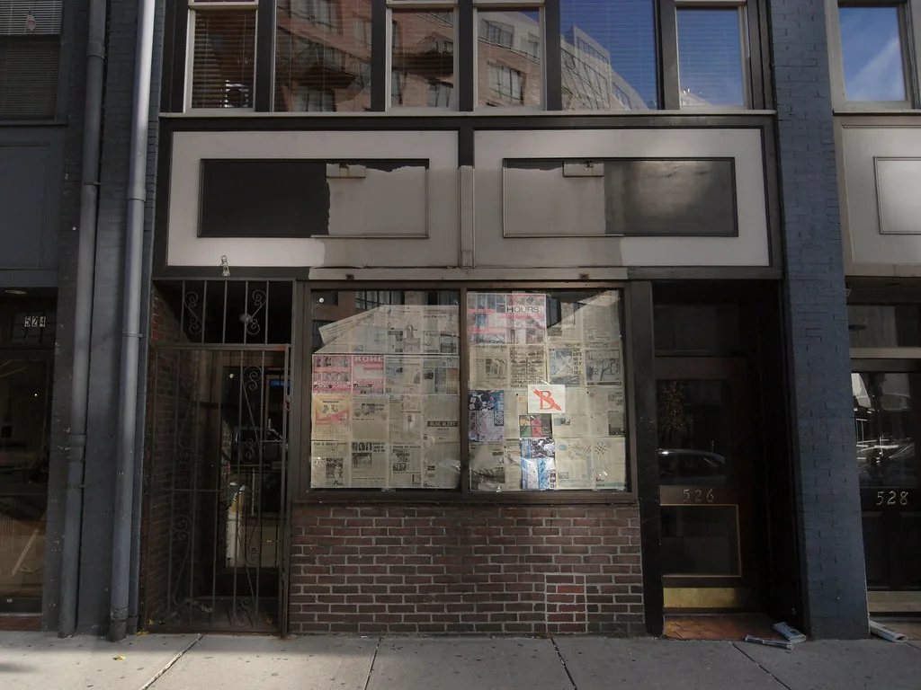 Closed frontage of The Movie Place with a paper-covered shop window.