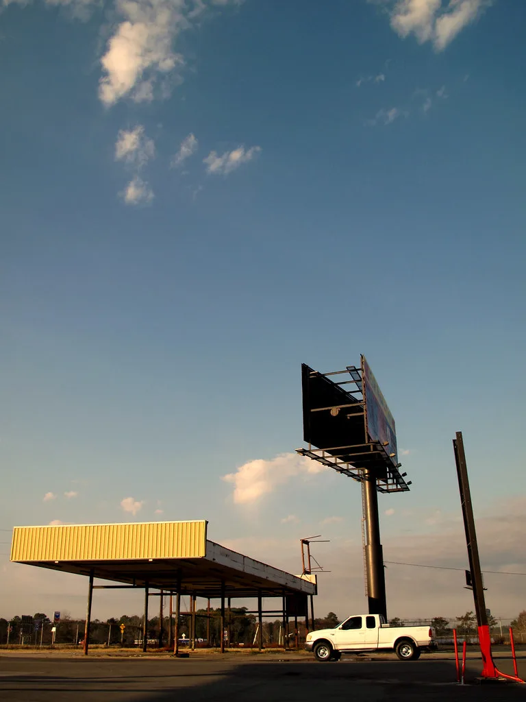 Deteriorated canopy of an old filling station with its pumps removed.