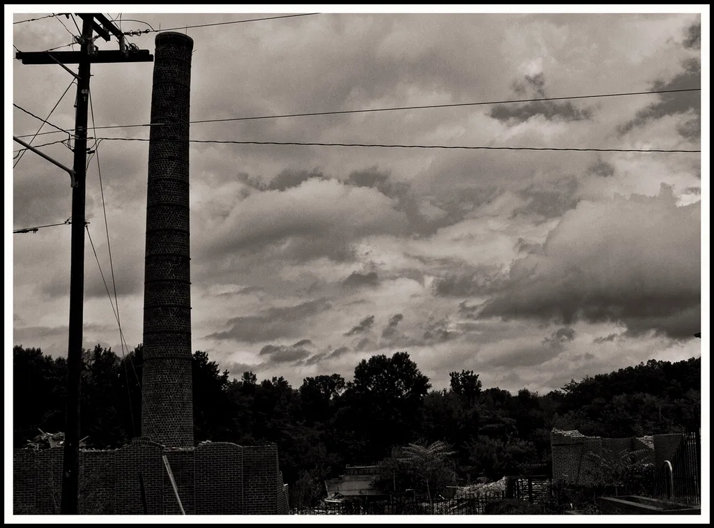 Brick chimney and ruined walls of a former industrial site.