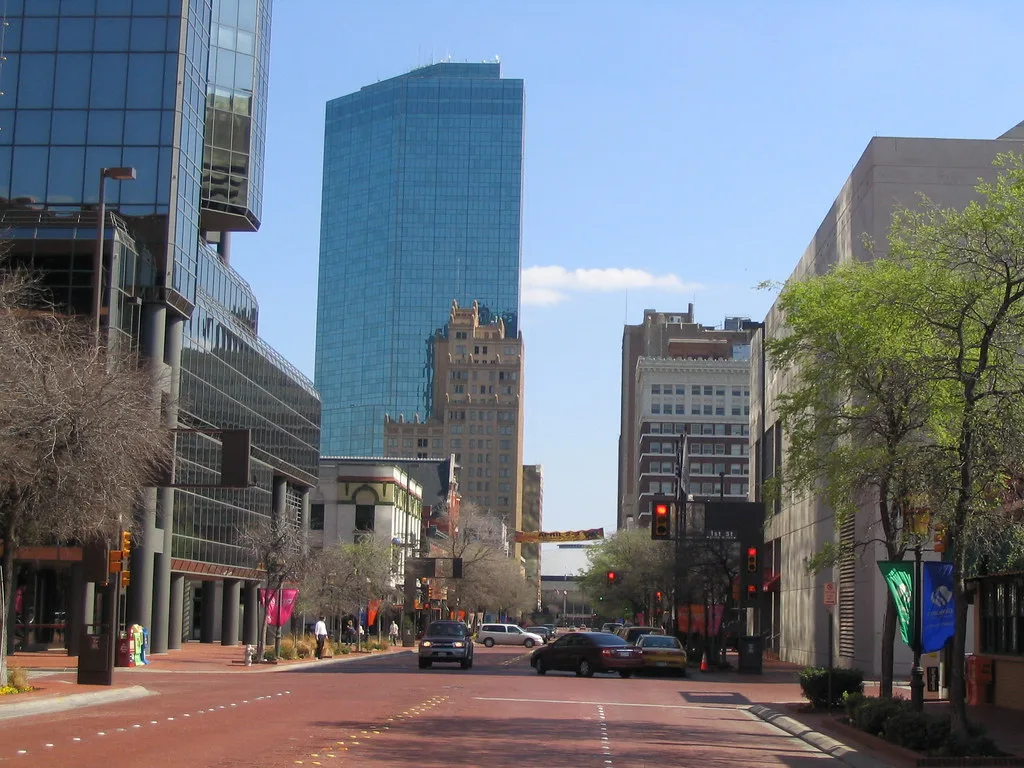 Main Street in downtown Fort Worth, between older buildings and glass towers.