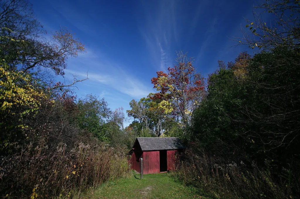 Small red building at Stute Springs and Homestead at the end of a grassy path.
