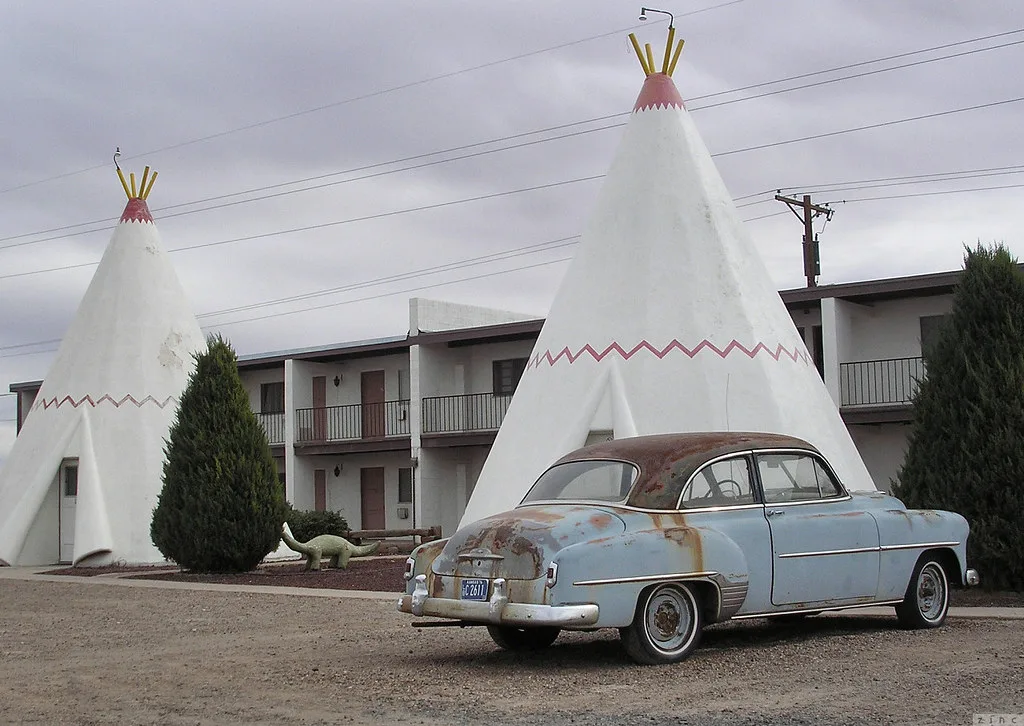 Cabanes coniques du Wigwam Motel à Holbrook, avec une voiture ancienne au premier plan.