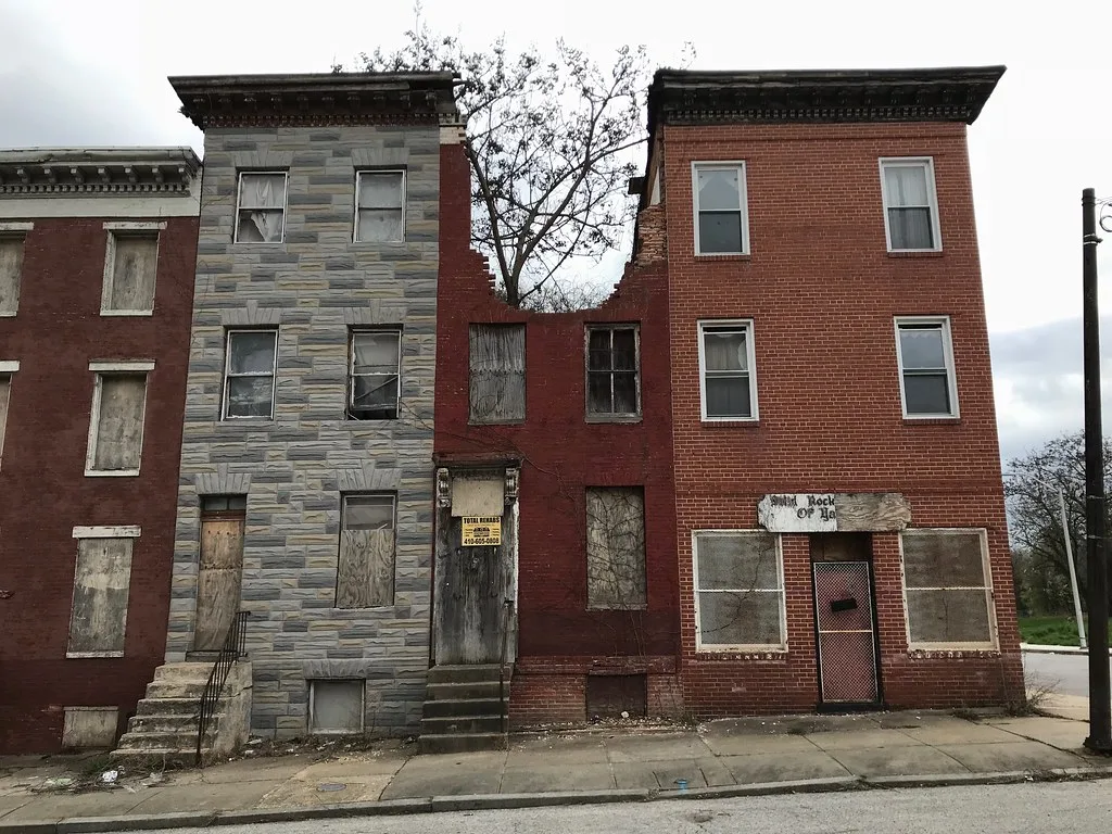 Decaying terraced houses including a partly collapsed facade.