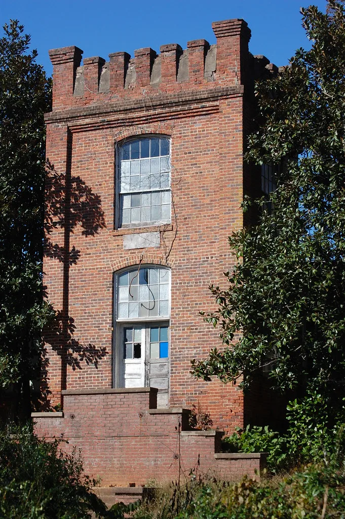Brick entrance to a former textile mill with broken windows.