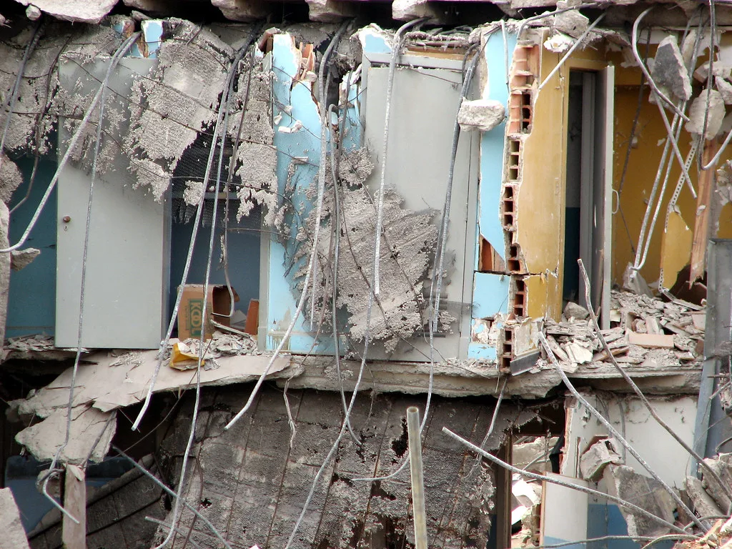 Exposed rooms with broken partitions and visible metal reinforcement.