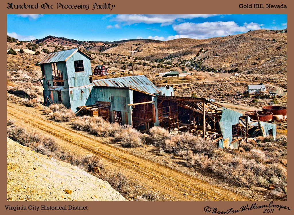 Old blue metal mining facility with collapsed frames on an arid hillside.