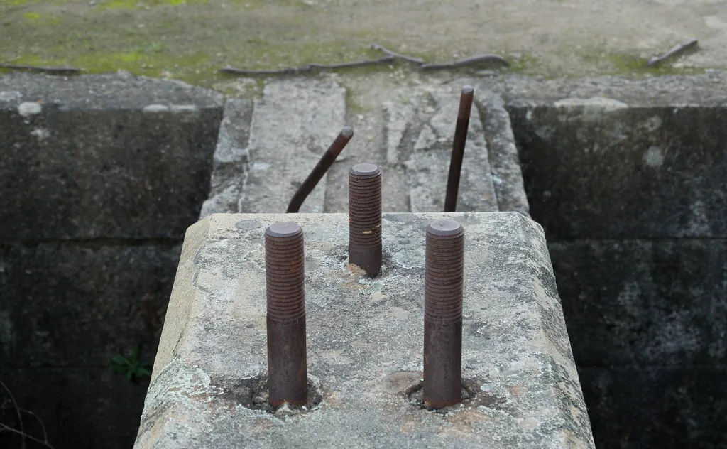 Boulons rouillés sur d’anciens supports en béton abîmés.