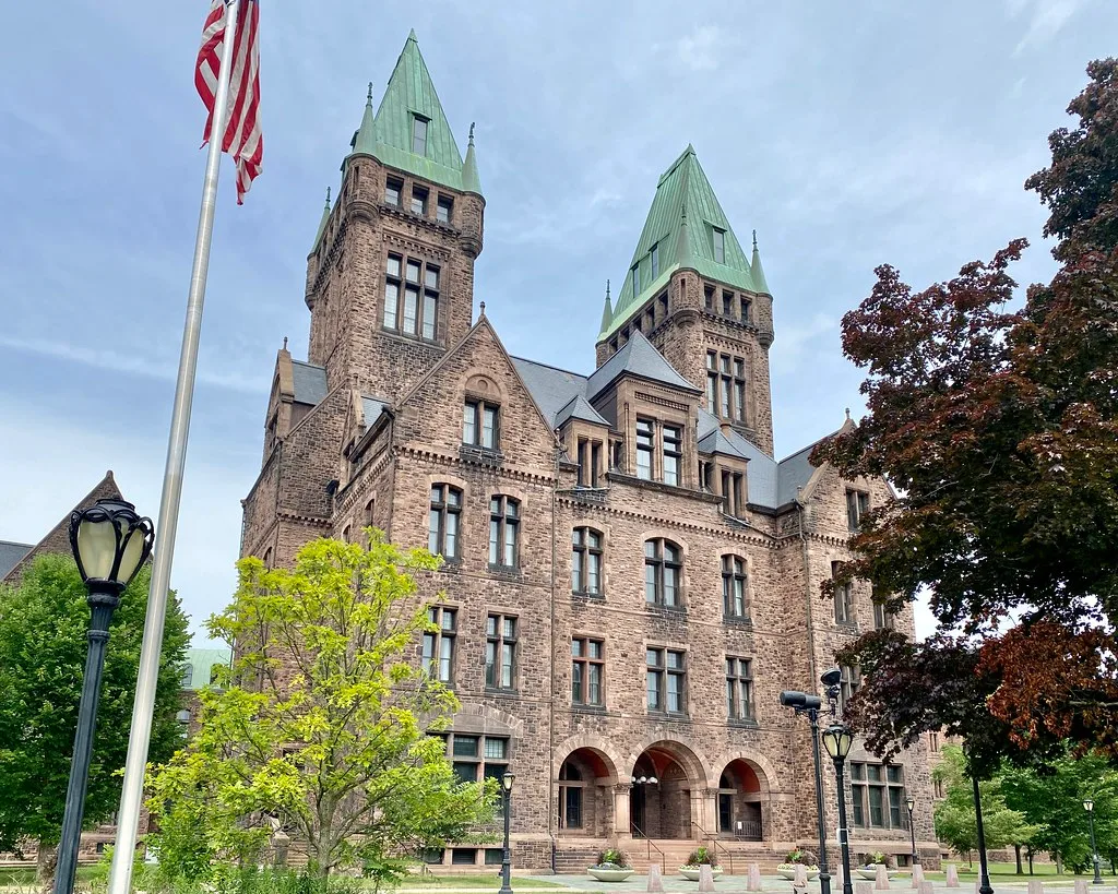 Central wing of the former Buffalo State Hospital with two green-roofed towers.