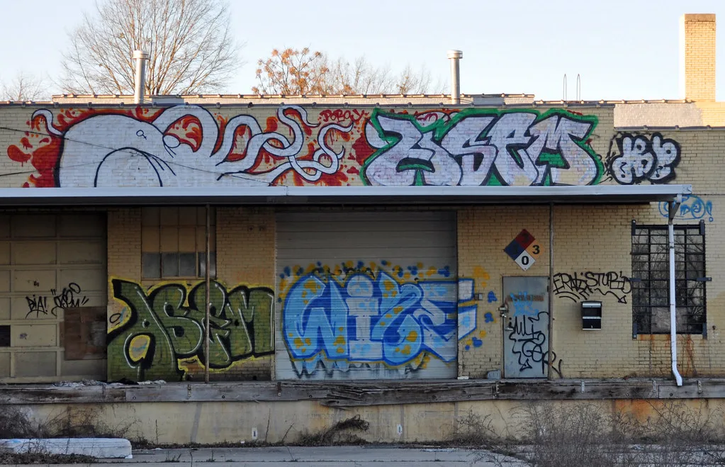 Old loading dock with closed doors and a graffiti-covered facade.