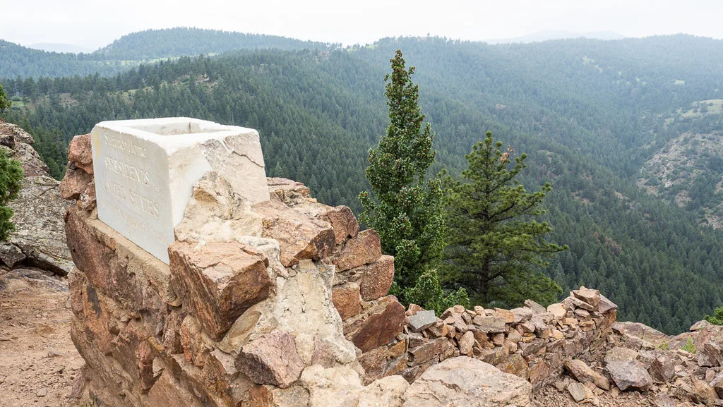 Stone wall remains above a wooded valley.