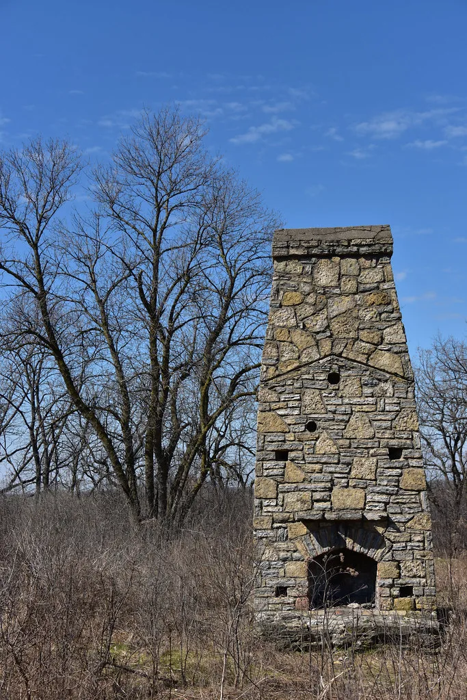 Old freestanding stone chimney in scrubland.
