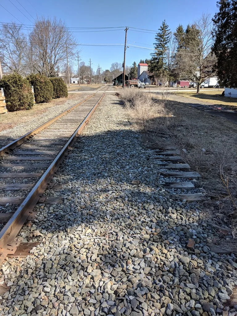 Old railway tracks, one with its rails removed.