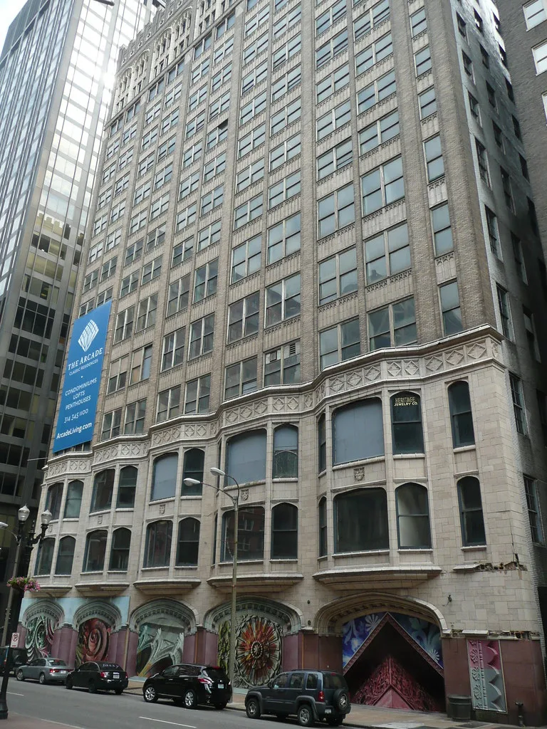 Old stone building with its ground-floor arcades boarded with painted panels.