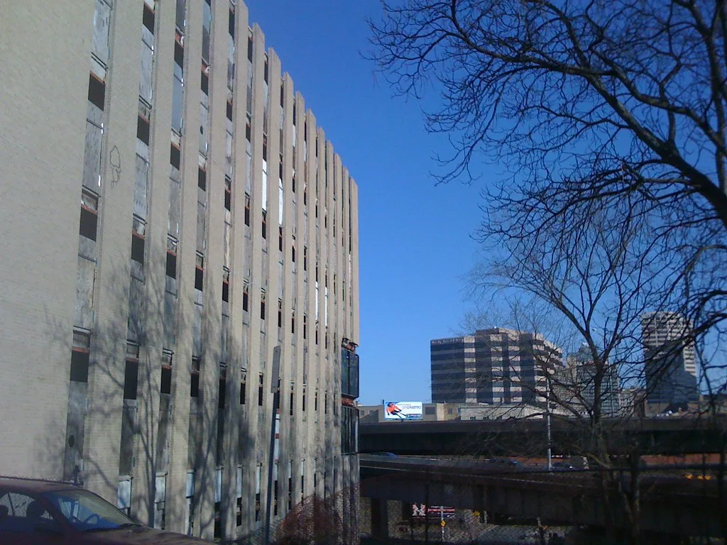 Old building with rows of empty and boarded windows.