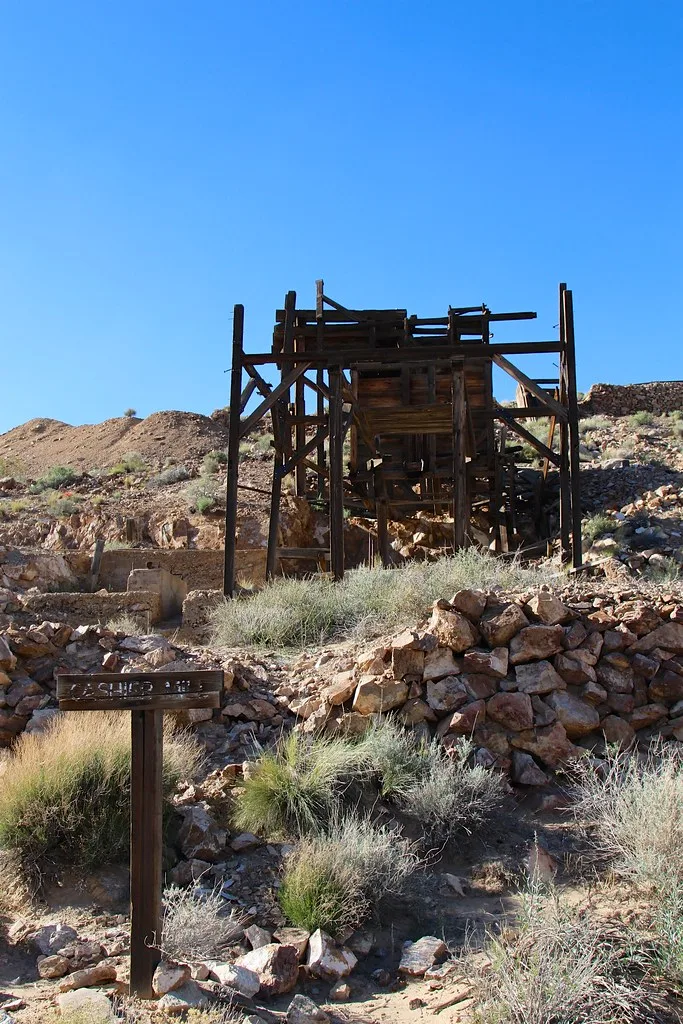 Abandoned wooden industrial framework on a rocky arid slope.
