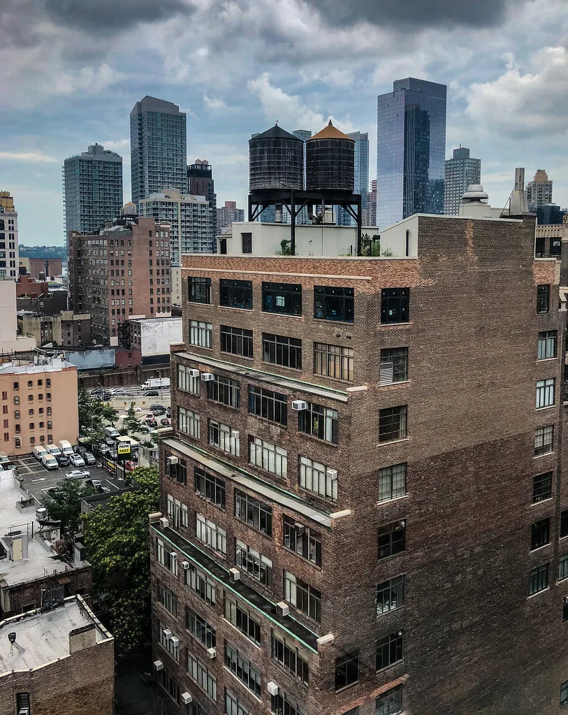 Immeuble en brique de Midtown Manhattan surmonté de deux réservoirs d'eau.