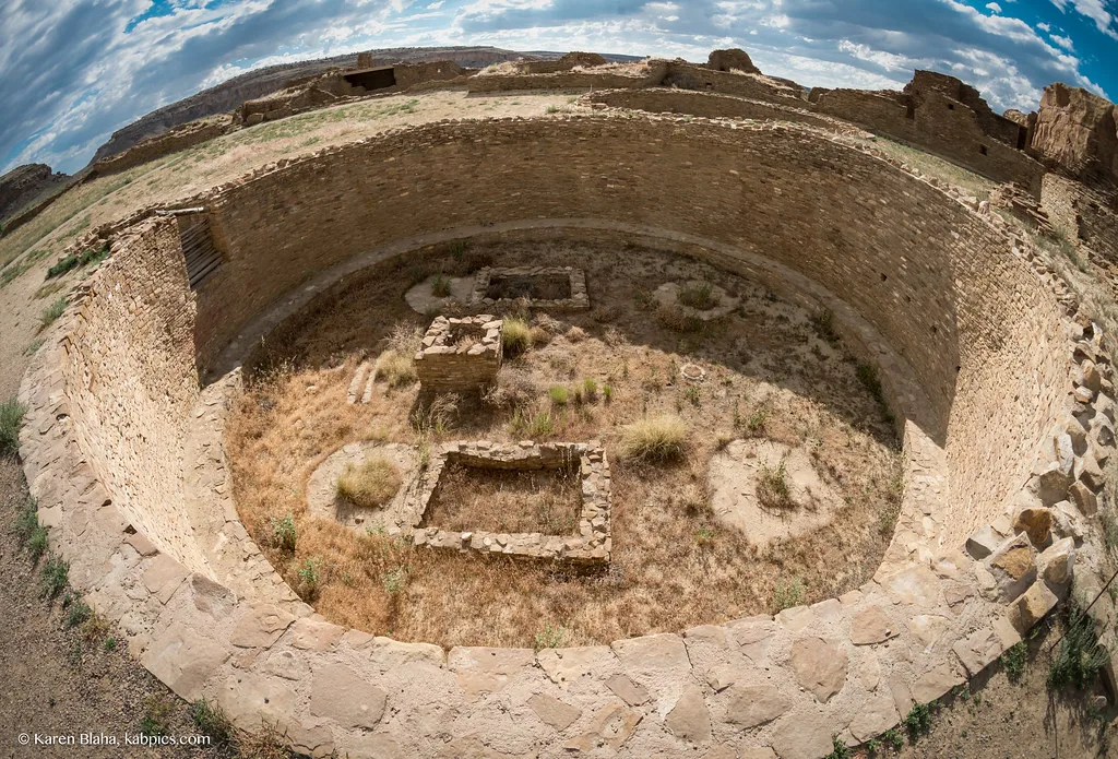 Ruins of a circular stone enclosure in an arid landscape.