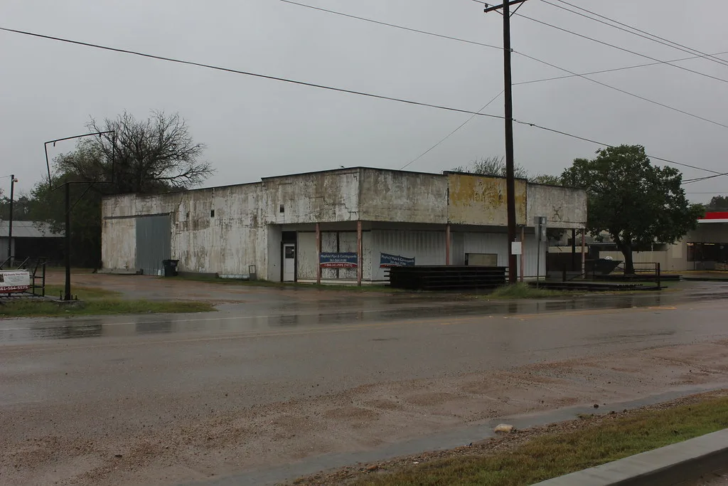 Bâtiment abandonné à Yorktown au Texas, avec une façade claire et des ouvertures condamnées.