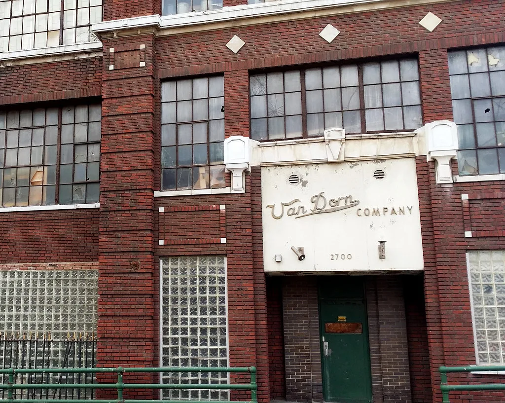 Entrance to an abandoned brick factory bearing Van Dorn Company lettering beneath windows with broken panes.