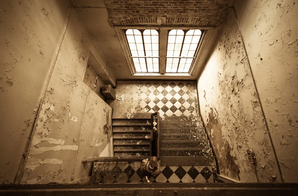 Escalier ancien aux murs écaillés, vu d’en haut.