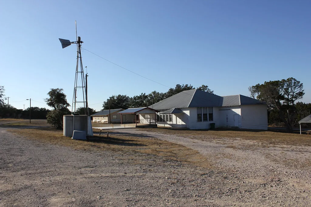 Centre communautaire d'Oatmeal au Texas, avec une éolienne devant le bâtiment.