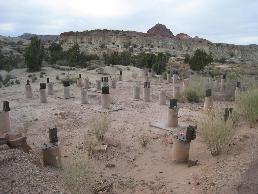 Rows of concrete footings and metal brackets in a desert landscape.