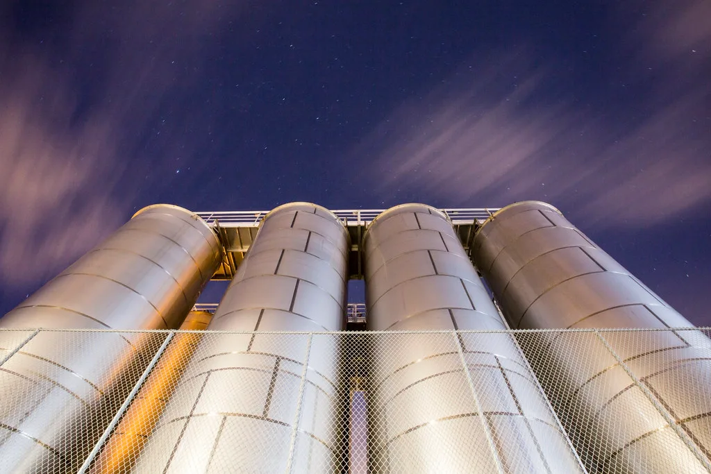 Silos industriels éclairés de nuit vus en contre-plongée à Berkeley