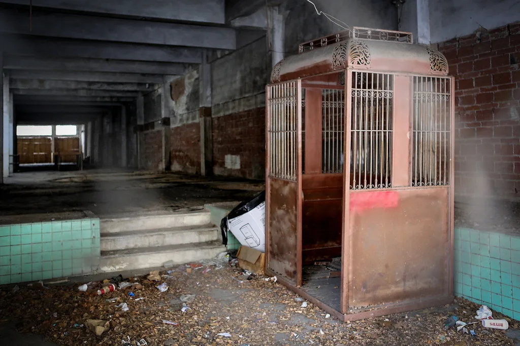 Old metal elevator cabin in a derelict room.