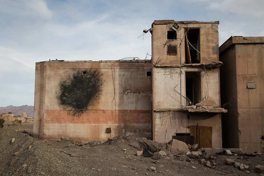 Old industrial facility with open damaged floors and debris on the ground.