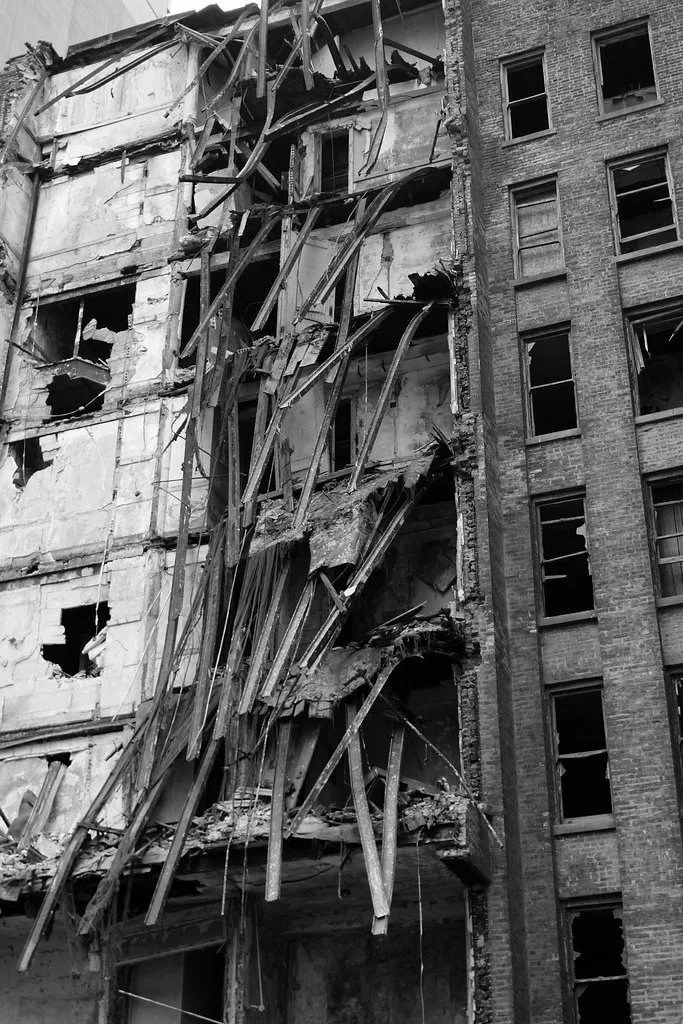 Large gutted building with collapsed floors, in black and white.