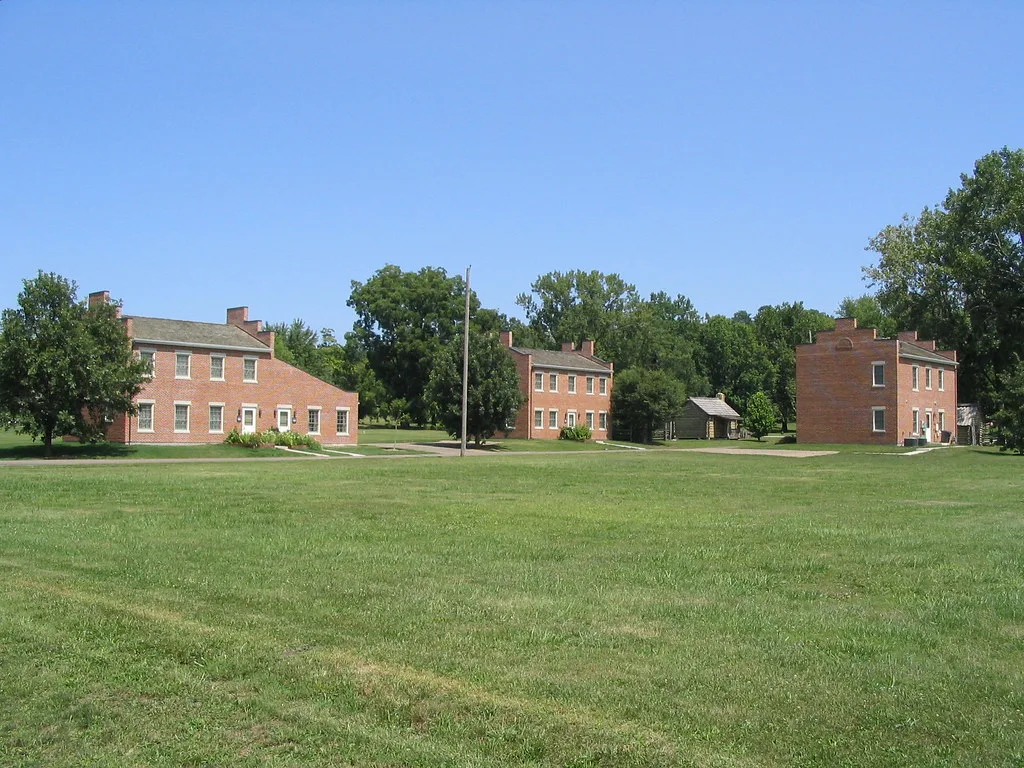 Maisons en brique du quartier historique de Nauvoo au-delà d'une pelouse.