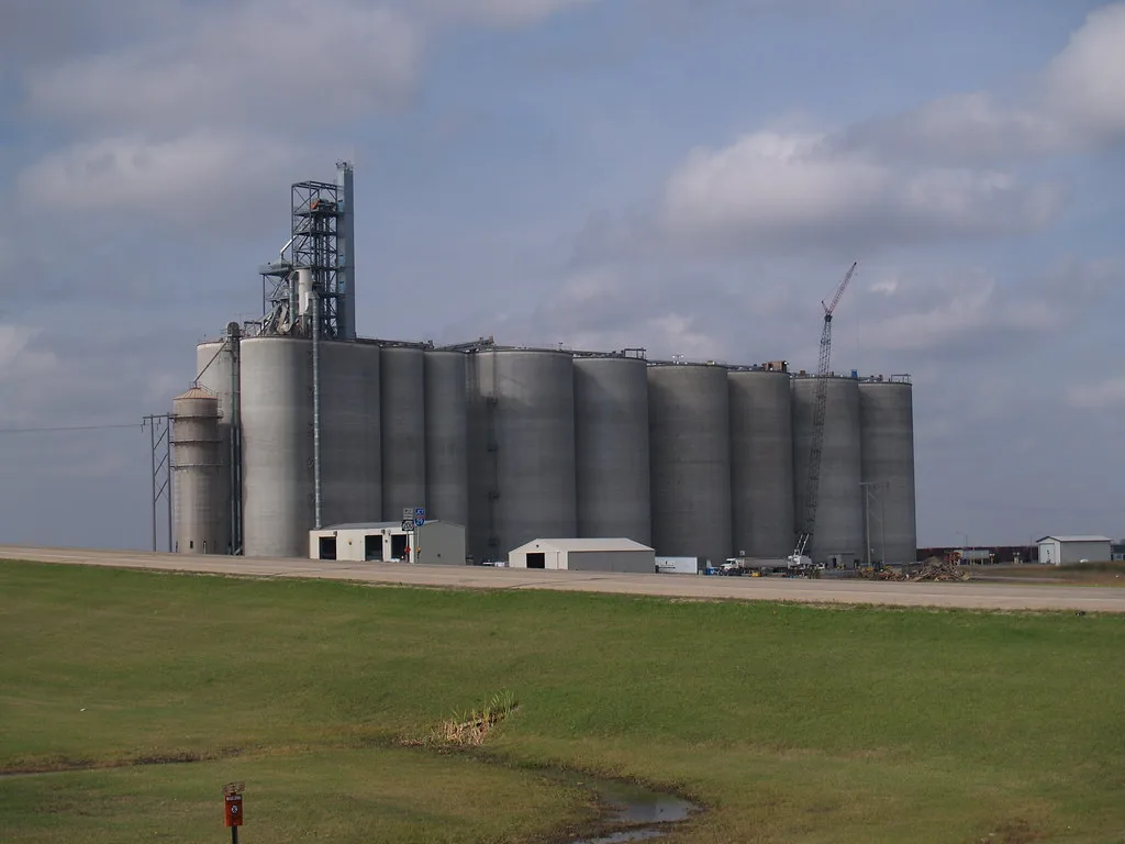 Concrete silos in Alton, North Dakota, beyond a grassy field.