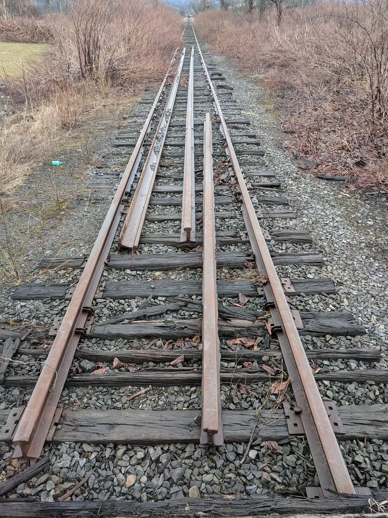 Old railway track with decayed sleepers and loose rails.
