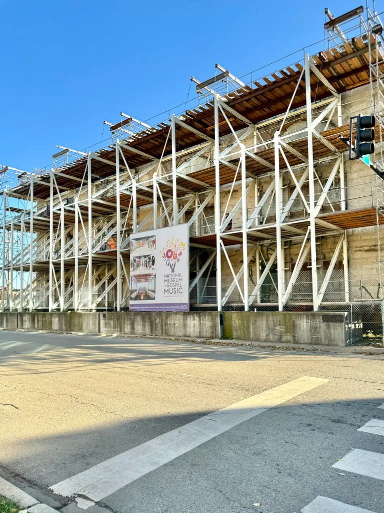 Façade de pierre ruinée maintenue par une structure d’étaiement.