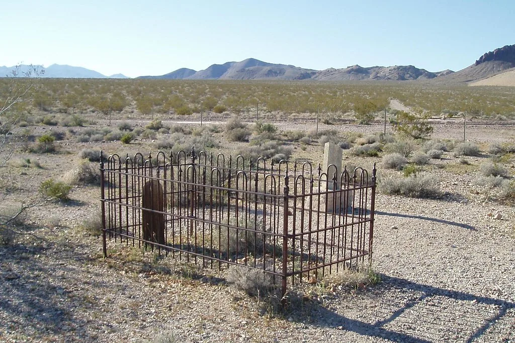 Graves enclosed by a metal fence in Rhyolite Cemetery.