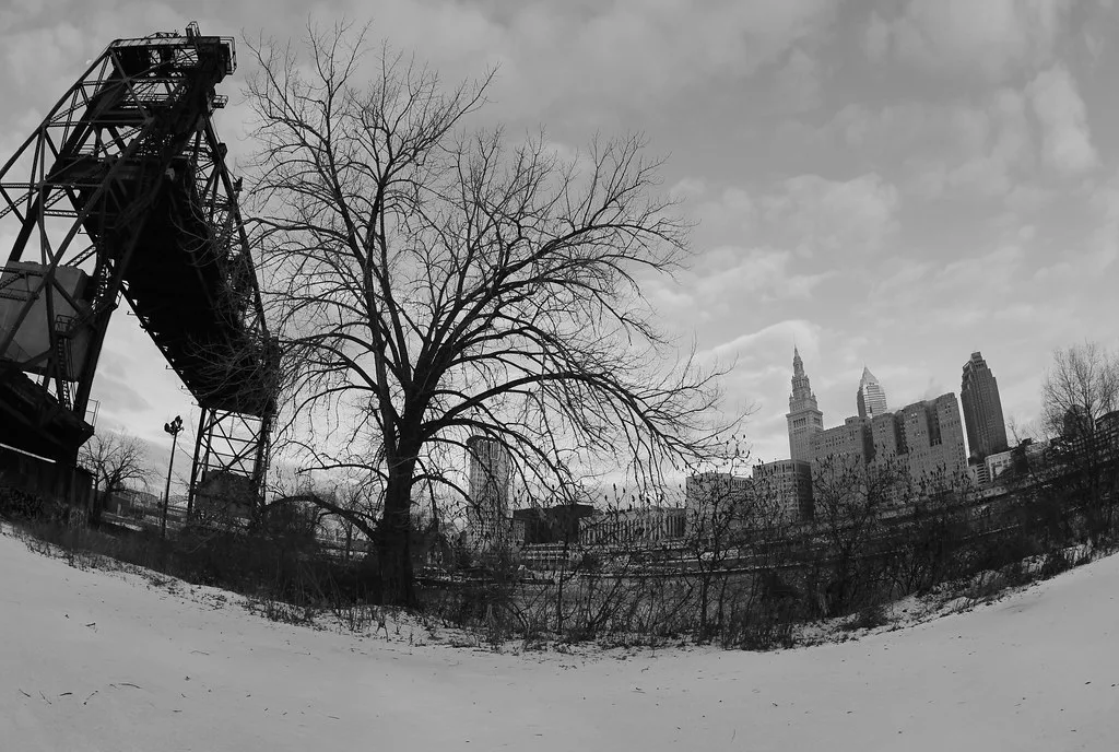 Old raised metal structure beside trees in the snow.