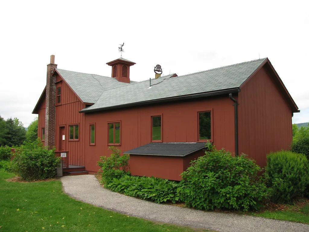 Norman Rockwell's former studio, a red building surrounded by greenery.