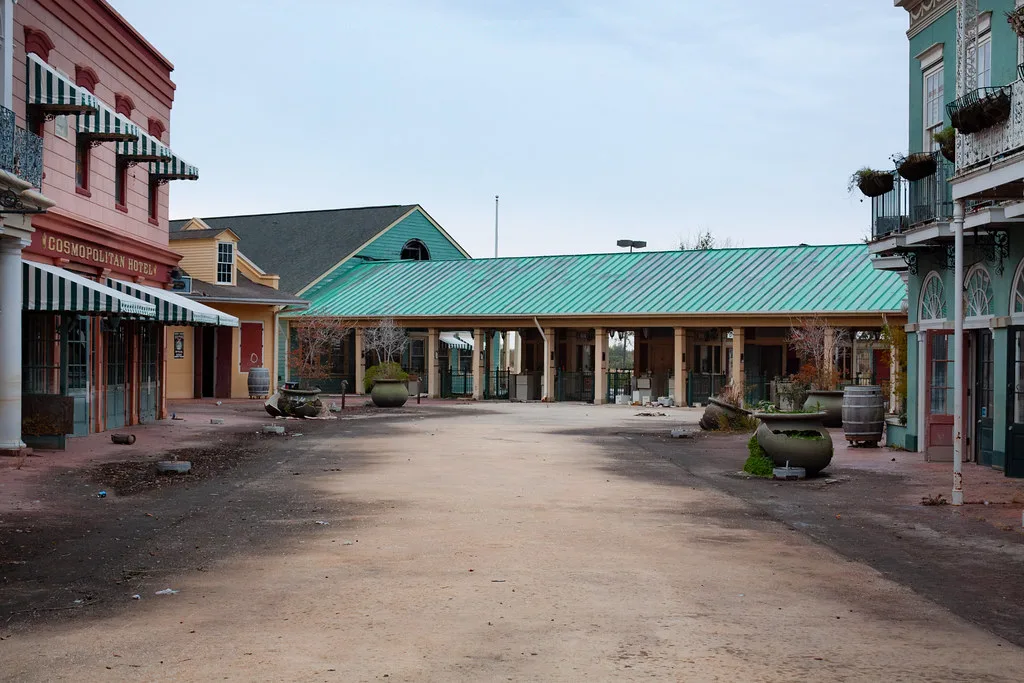 Deserted walkway between colorful facades and deteriorated planters.