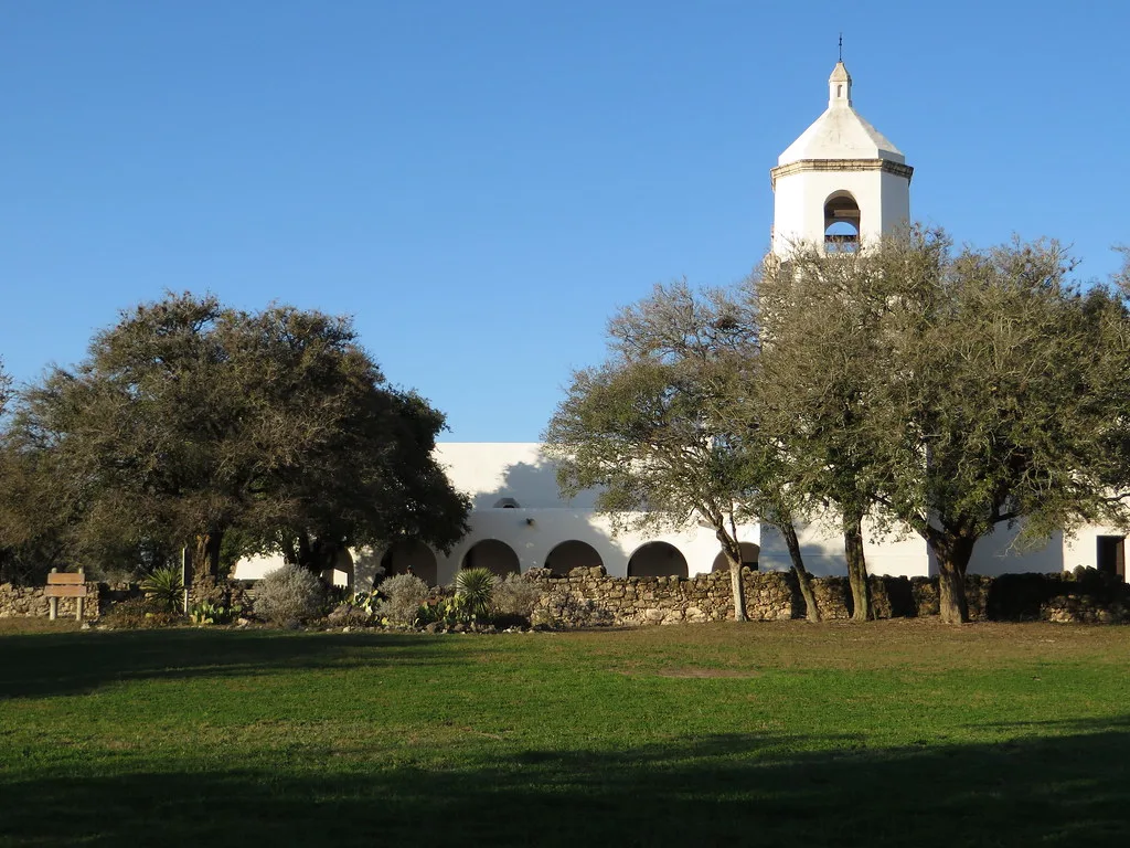 Bell tower and white arcades of Espíritu Santo Mission in Goliad.