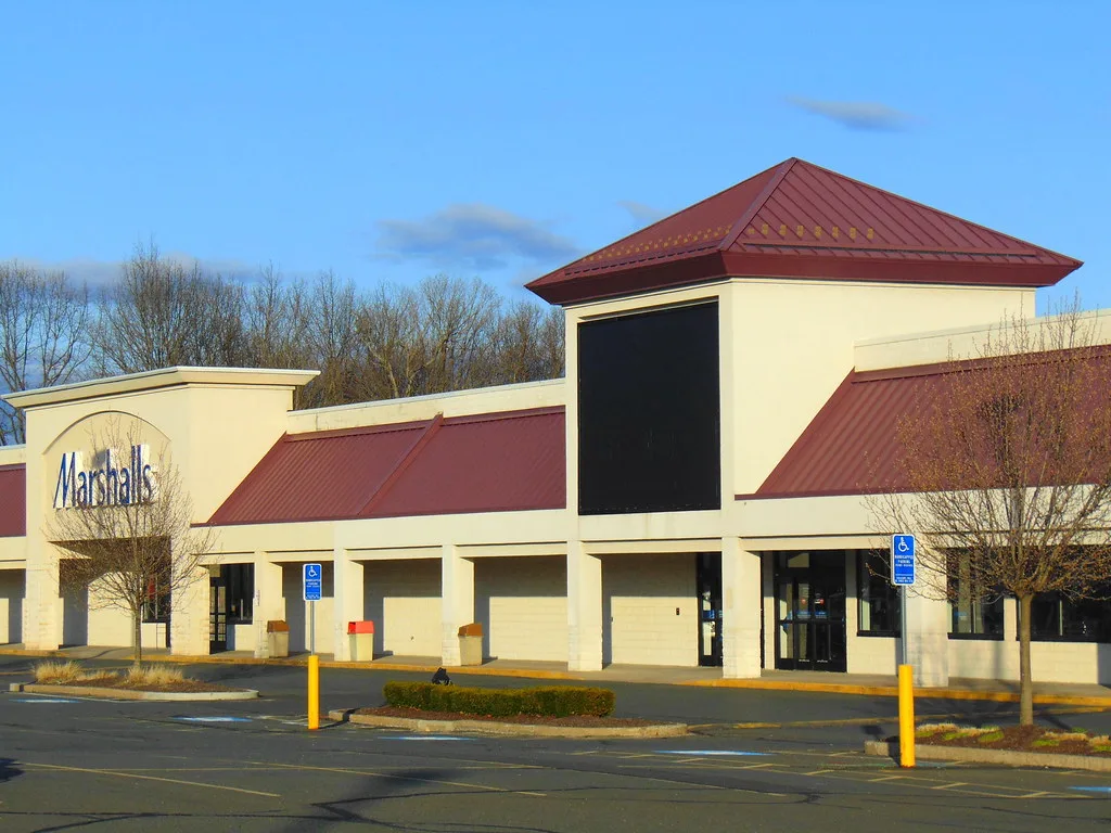 Yellow facade of the former Bob's Store in Manchester with an empty sign panel.