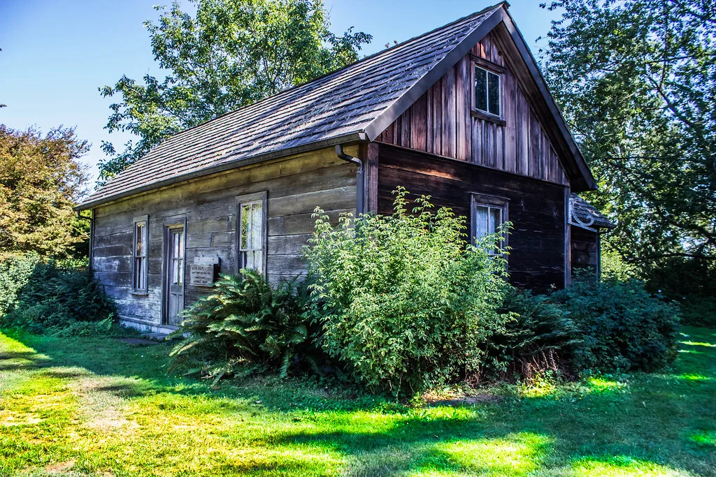 Timber house at Gehl Homestead surrounded by shrubs.