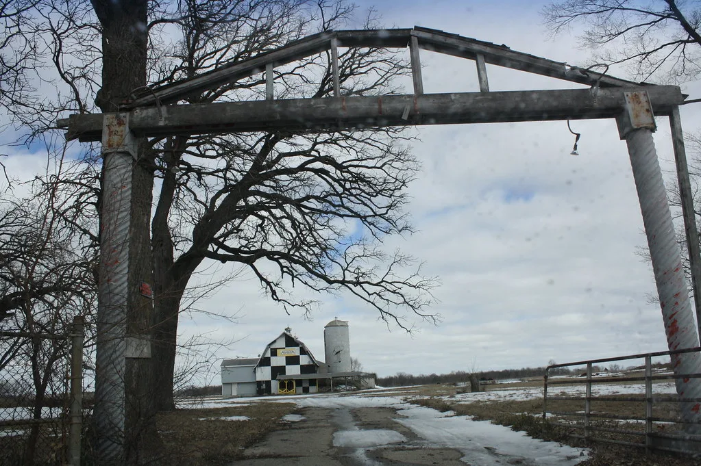 Deteriorated entrance frame at Lake Geneva Raceway, with a checkered building in the background.