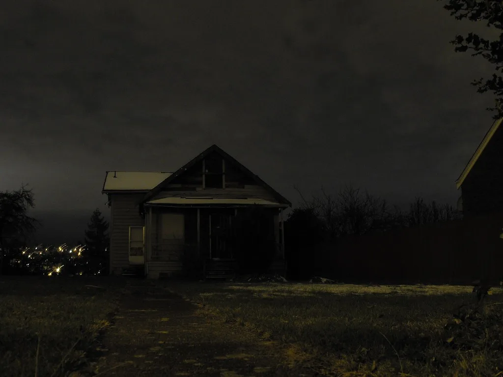 Deteriorated old house photographed at night.