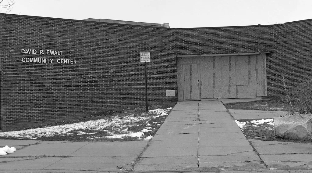 Boarded entrance to a former brick community centre.