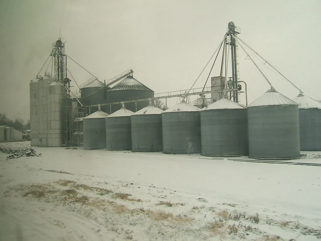 Group of grain silos in a snowy landscape.