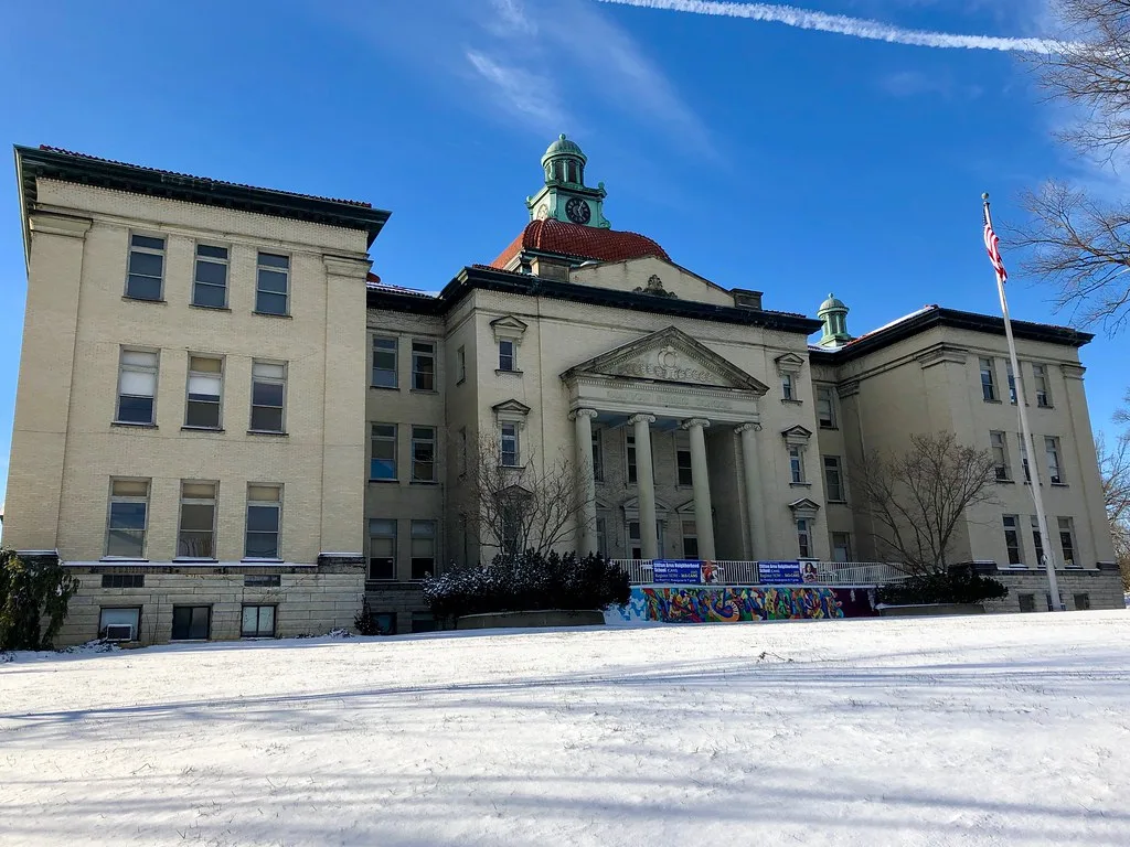 École Clifton à Cincinnati, avec son portique à colonnes et son clocheton, devant une pelouse enneigée.