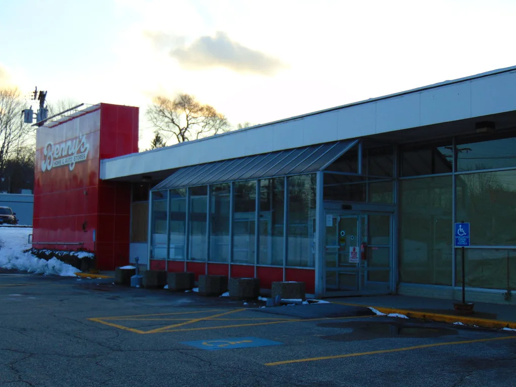Glazed facade of Benny's store in Norwich with a red sign.