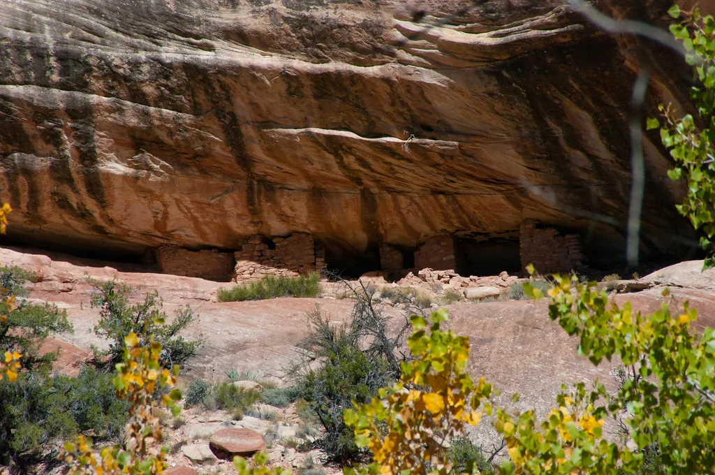 Masonry ruins beneath a large rock overhang.