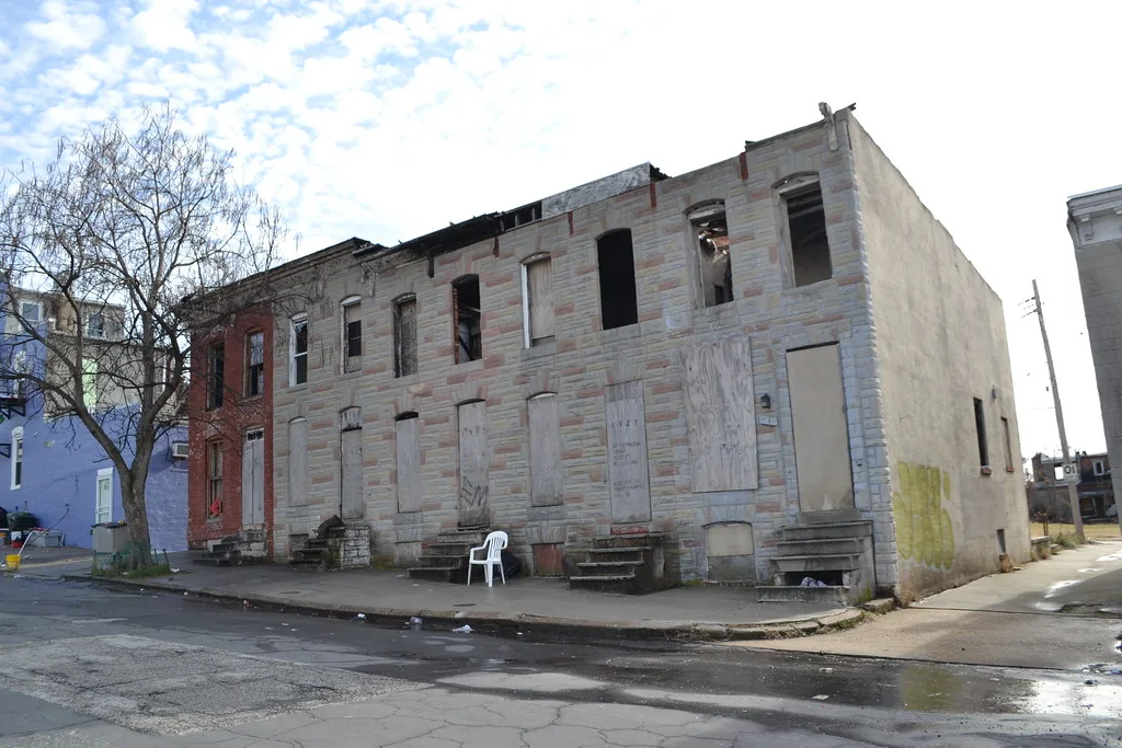 Abandoned row houses with empty windows and boarded doors.