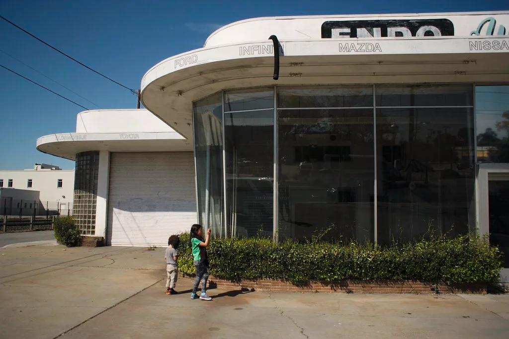 Former garage with a rounded glass facade and weathered signs.